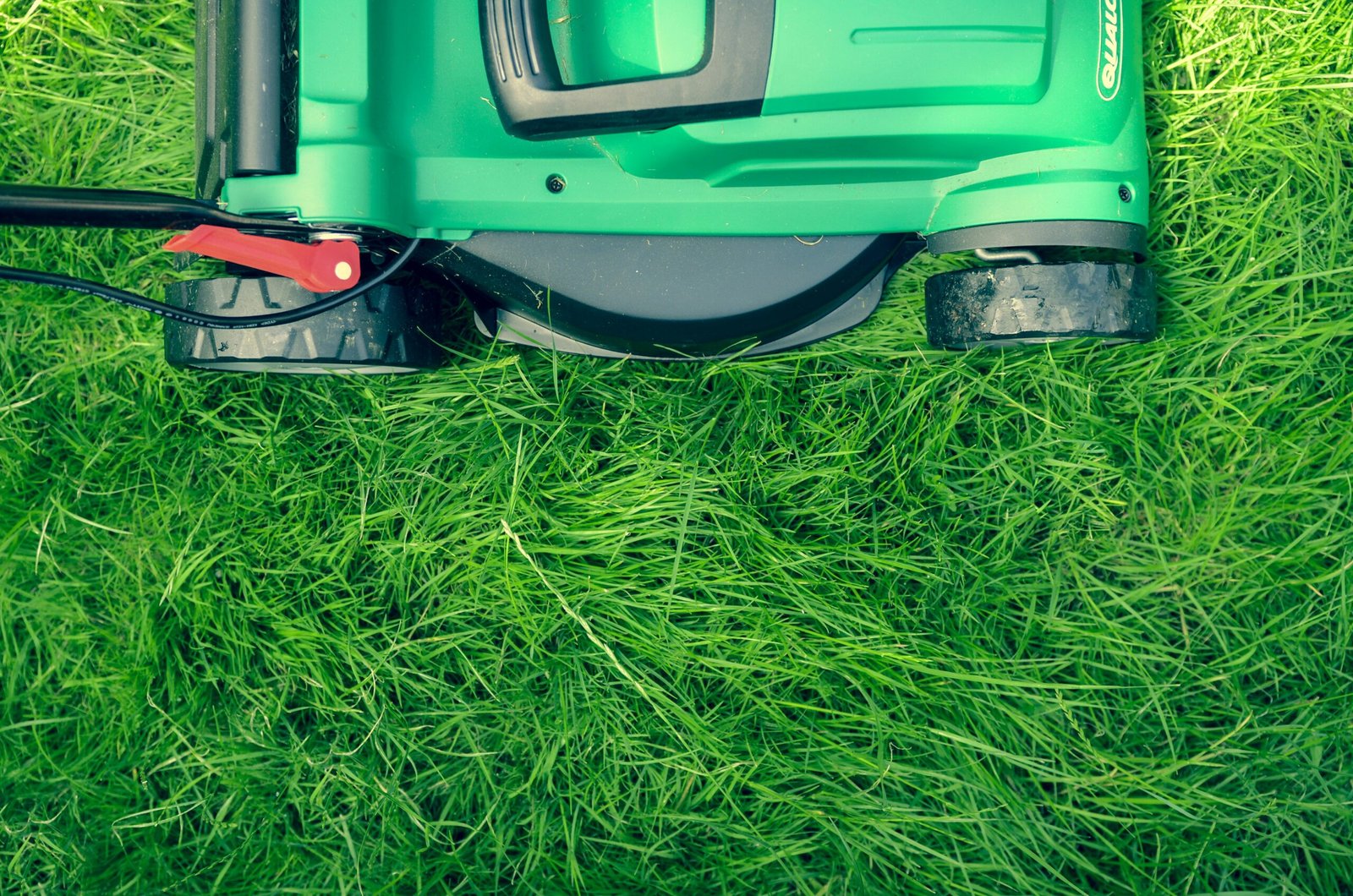 Partial image of a lawn mower on grass.